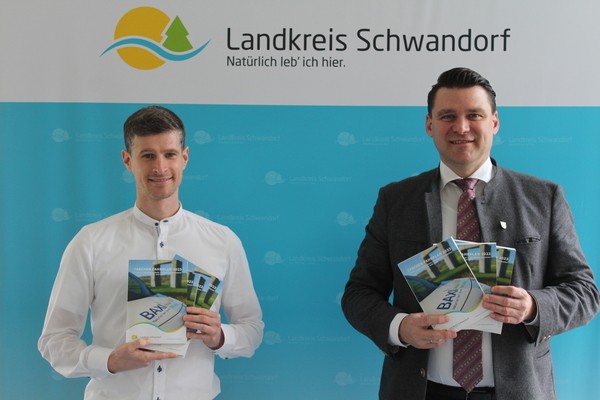 © Landrat Thomas Ebeling (rechts) und der ÖPNV-Beauftragte am Landratsamt Schwandorf, Dominik Hauser, stellen den neuen Taschenfahrplan 2023 vor. (Foto: Manuel Lischka, Landratsamt Schwandorf)